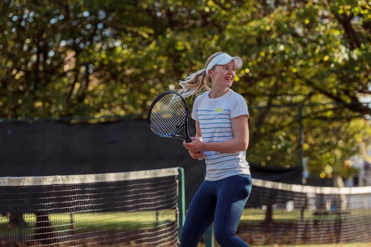 A woman playing tennis in Birkenhead Park
